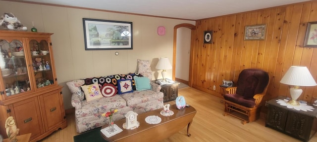 living room featuring crown molding and light hardwood / wood-style flooring