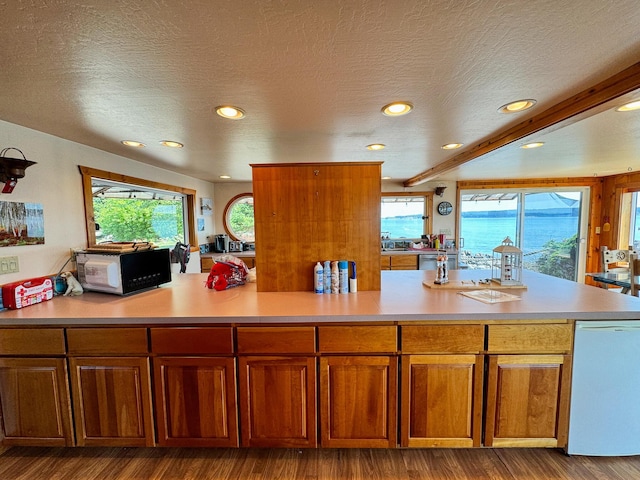 kitchen featuring beam ceiling, hardwood / wood-style floors, and a textured ceiling