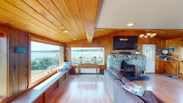 living room with lofted ceiling with beams, wooden ceiling, light hardwood / wood-style floors, and wood walls