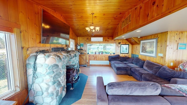 living room with lofted ceiling, wood ceiling, an inviting chandelier, light hardwood / wood-style floors, and wood walls