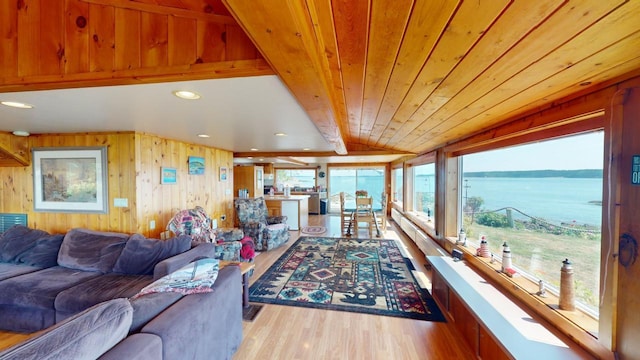 living room with wood walls, lofted ceiling, wood ceiling, a water view, and light hardwood / wood-style flooring