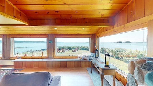 sunroom featuring a water view, lofted ceiling, and wood ceiling