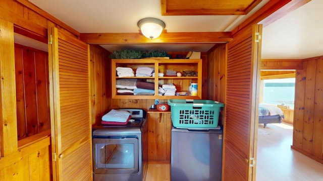 laundry room with separate washer and dryer and wooden walls