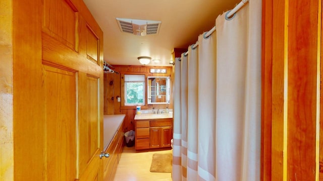 bathroom featuring walk in shower and vanity