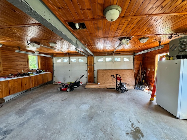 garage featuring white refrigerator, a garage door opener, and wooden ceiling