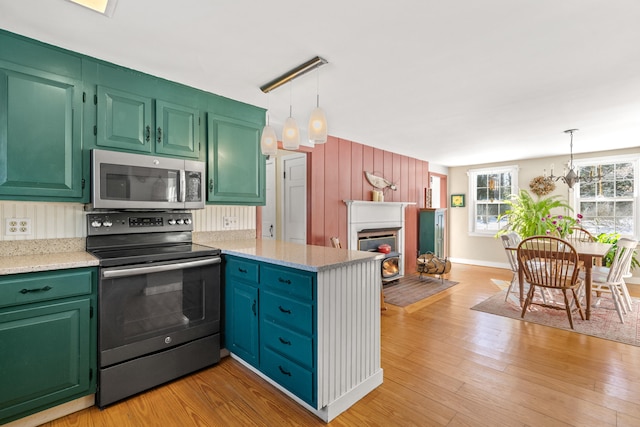 kitchen featuring a peninsula, electric range, stainless steel microwave, and light wood-style flooring