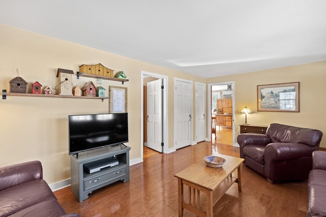 living area featuring baseboards and wood finished floors