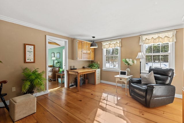 sitting room featuring light wood-type flooring, plenty of natural light, baseboards, and crown molding