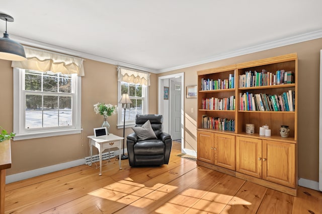 sitting room featuring ornamental molding, light wood finished floors, and baseboards