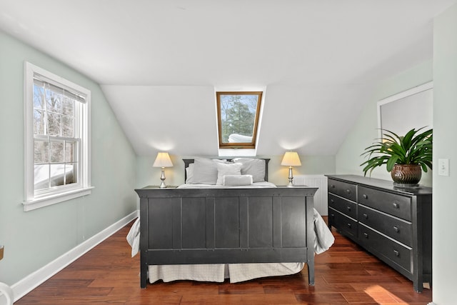 bedroom featuring dark wood-style floors, baseboards, and lofted ceiling with skylight