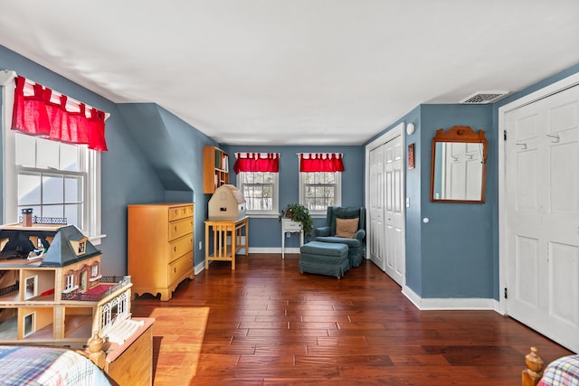 living area featuring baseboards, visible vents, and hardwood / wood-style floors