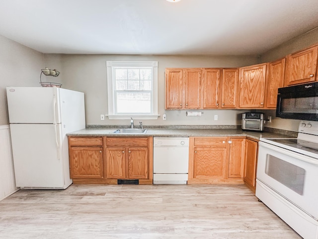 kitchen with sink, white appliances, and light hardwood / wood-style flooring