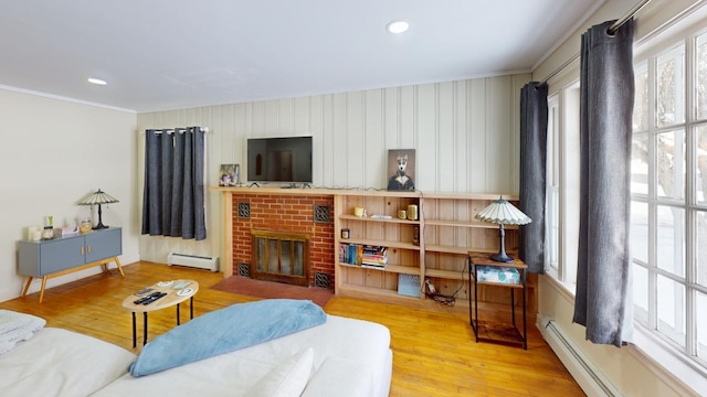 living room featuring baseboard heating, a brick fireplace, wood finished floors, and recessed lighting