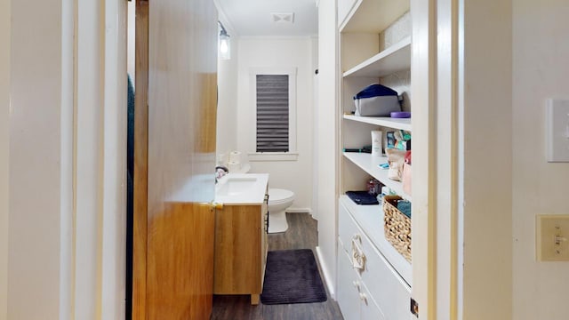 bathroom with toilet, visible vents, wood finished floors, and vanity