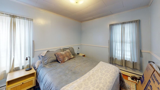 bedroom featuring a baseboard heating unit, a baseboard radiator, and crown molding