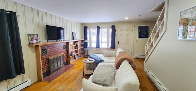 living area with light wood finished floors, a baseboard radiator, and baseboard heating