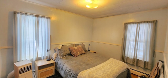 bedroom with a baseboard radiator and crown molding