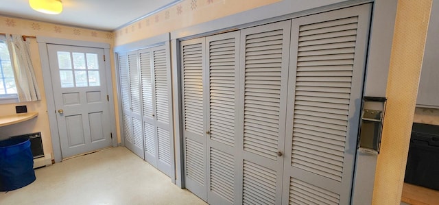 doorway to outside featuring wallpapered walls