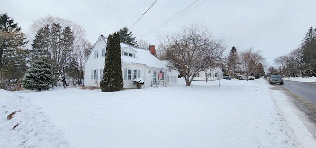 snow covered property with a chimney