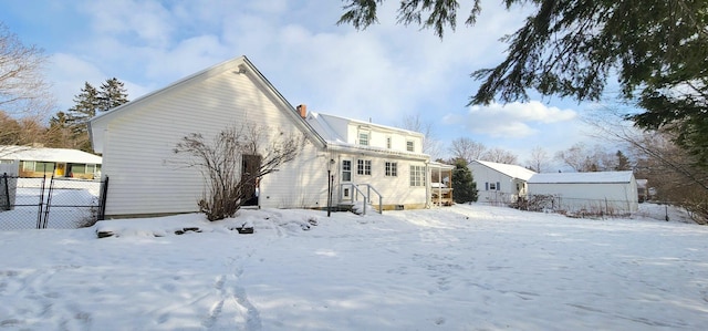 snow covered back of property with fence