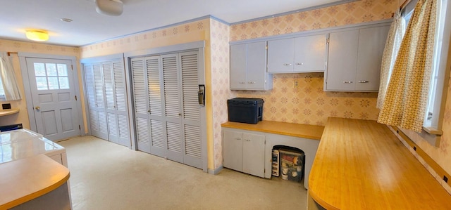 kitchen with light countertops, gray cabinetry, and wallpapered walls