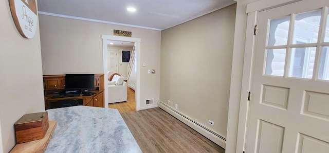 bedroom featuring baseboards, visible vents, light wood-style flooring, baseboard heating, and crown molding