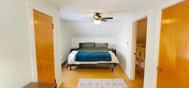 bedroom with lofted ceiling, ceiling fan, baseboards, light wood-style floors, and ornamental molding