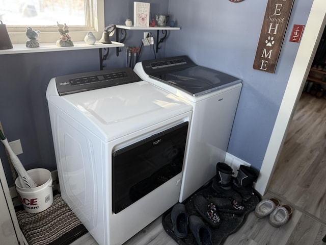 laundry area with light hardwood / wood-style floors and independent washer and dryer