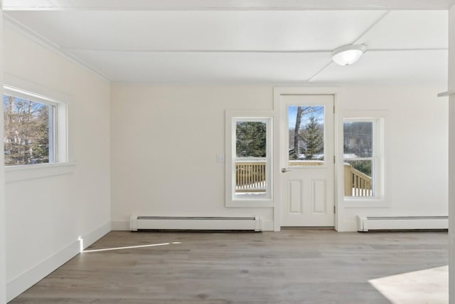 doorway to outside with baseboard heating, wood finished floors, and baseboards