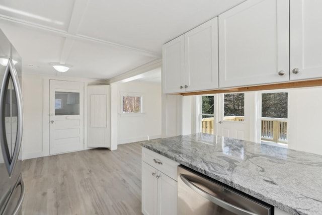 kitchen with light wood finished floors, appliances with stainless steel finishes, white cabinets, light stone countertops, and baseboards