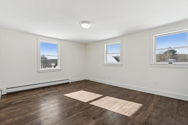 spare room with a baseboard heating unit, wood-type flooring, and baseboards