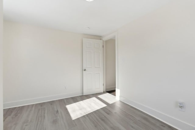 unfurnished room with baseboards and wood finished floors