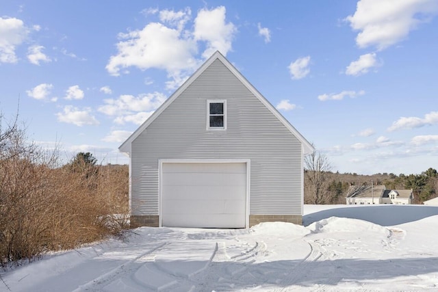 snow covered garage featuring a garage