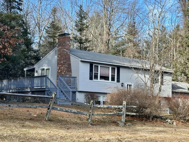 view of front of property with fence, a chimney, and a wooden deck