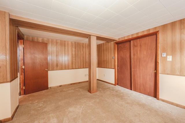 finished basement with wood walls and light colored carpet