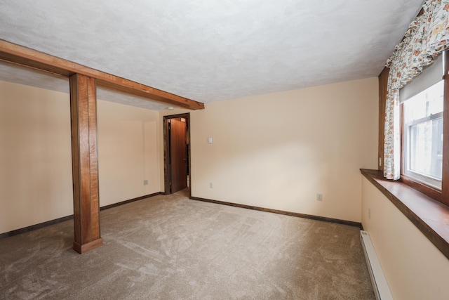 below grade area featuring a baseboard heating unit, carpet, a textured ceiling, and baseboards