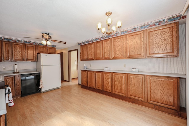 kitchen featuring light countertops, light wood-type flooring, freestanding refrigerator, brown cabinets, and dishwasher