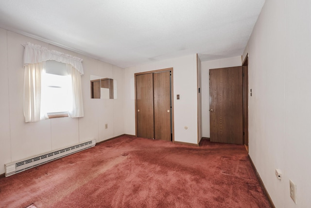 unfurnished bedroom with a closet, a baseboard heating unit, and carpet flooring