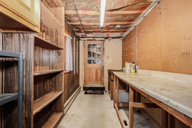 basement with a baseboard heating unit and a workshop area