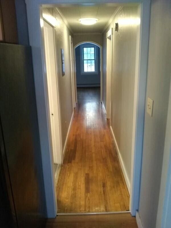 hall with hardwood / wood-style flooring and ornamental molding