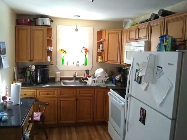 kitchen featuring sink, white appliances, decorative light fixtures, and light hardwood / wood-style floors