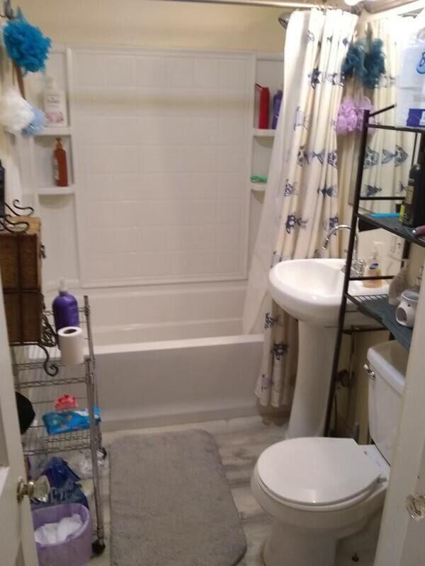 bathroom with shower / tub combo and toilet