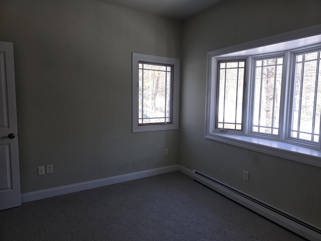 empty room featuring a baseboard radiator and dark colored carpet