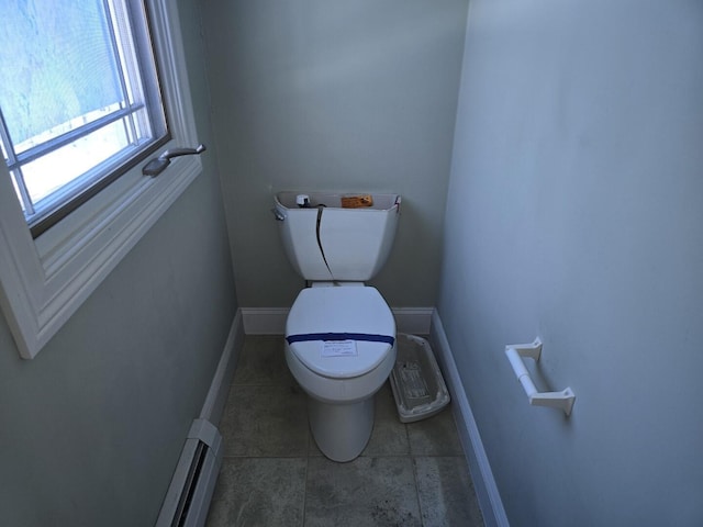 bathroom featuring tile patterned flooring, a baseboard heating unit, and toilet