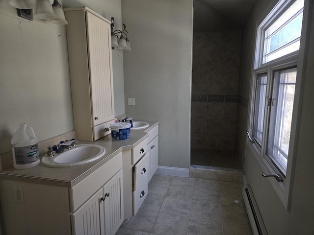 bathroom with vanity, tile patterned flooring, a baseboard radiator, and tiled shower