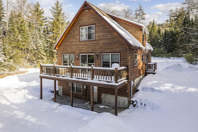 snow covered house with a wooden deck