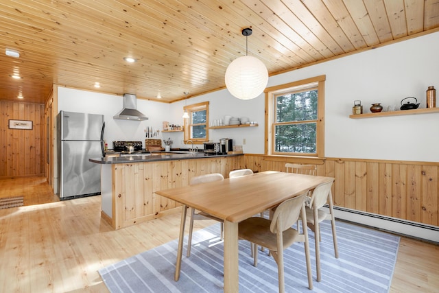 dining area featuring wooden ceiling, ornamental molding, wooden walls, light hardwood / wood-style floors, and a baseboard heating unit