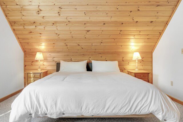 bedroom featuring vaulted ceiling, carpet, and wood ceiling