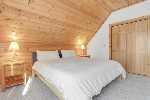 bedroom featuring light carpet, vaulted ceiling, wooden ceiling, and a closet