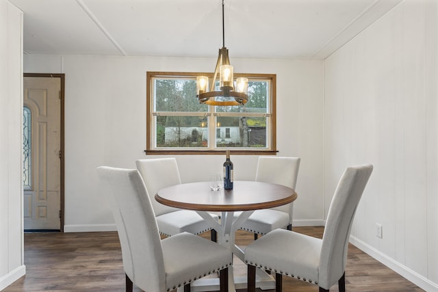 dining room with dark wood-type flooring and a chandelier